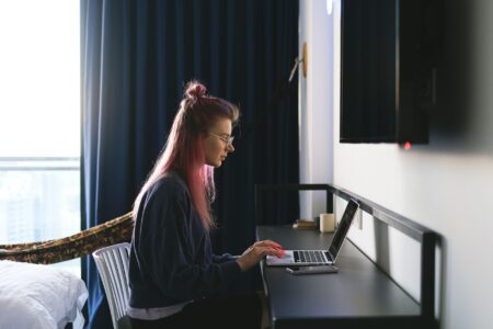 Freelancer working on a laptop at a desk managing social media accounts