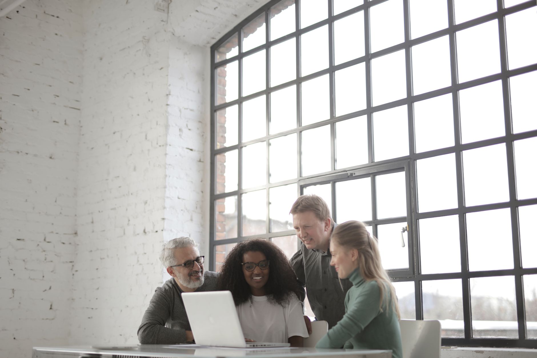 A small agency team reviewing social media content drafts together at a shared workspace