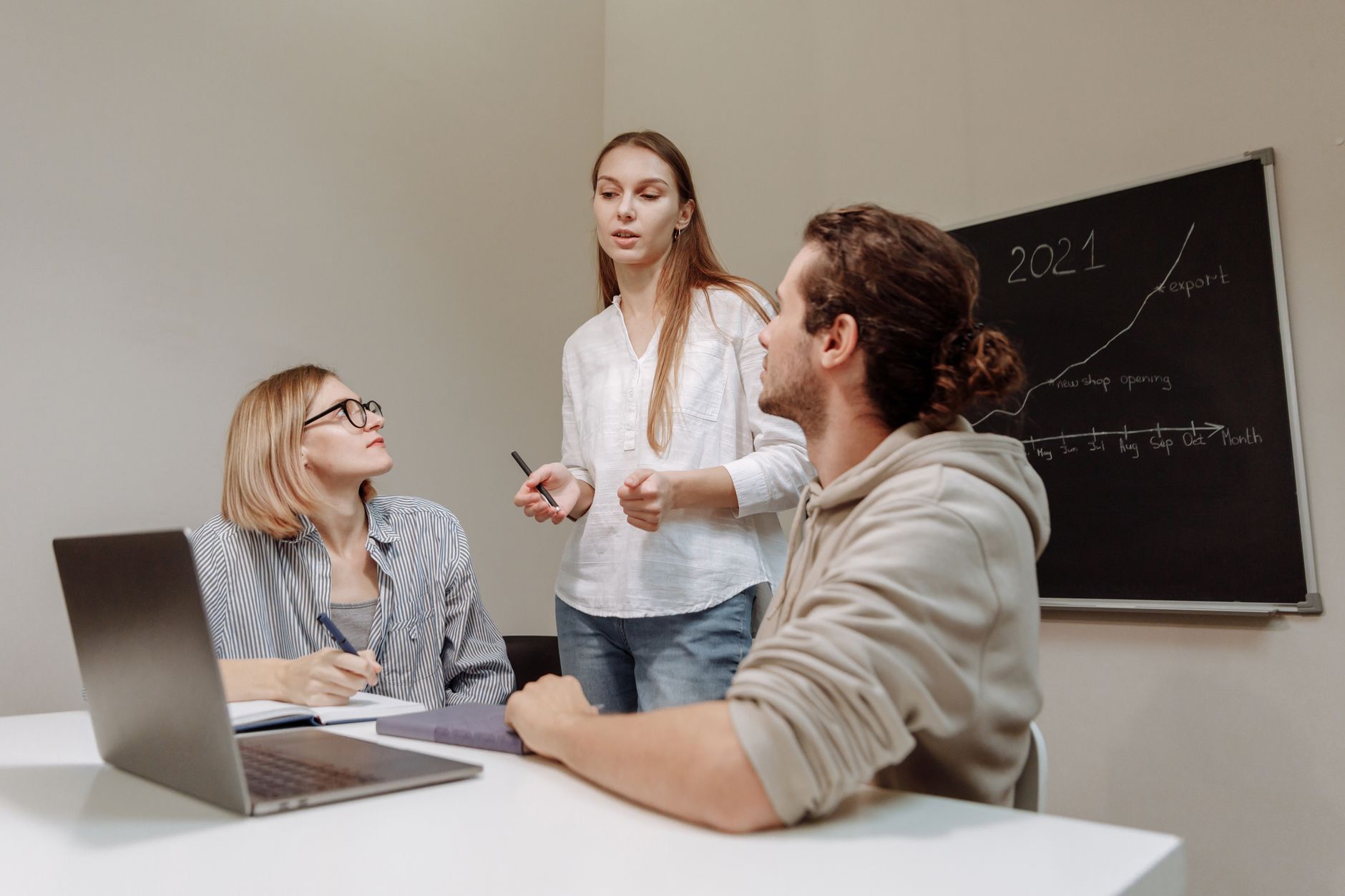 Marketing professionals reviewing digital strategy on laptops in a modern office