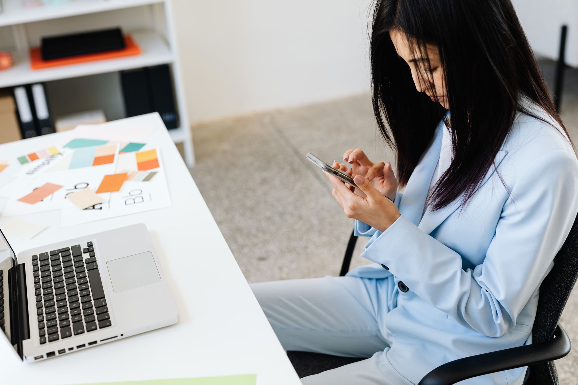 Woman working on social media content from her smartphone at a desk