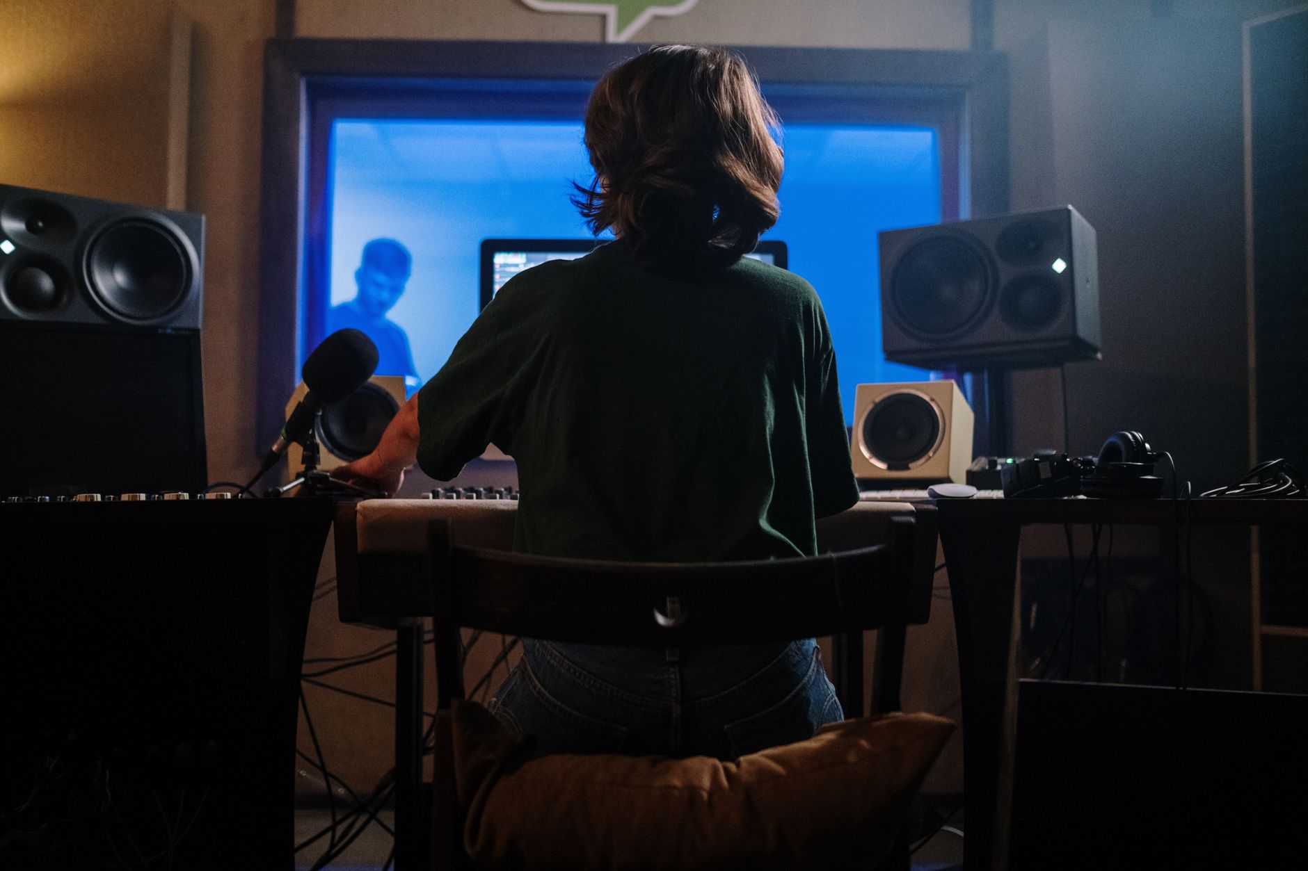 A solo creator recording a podcast episode at a home studio desk