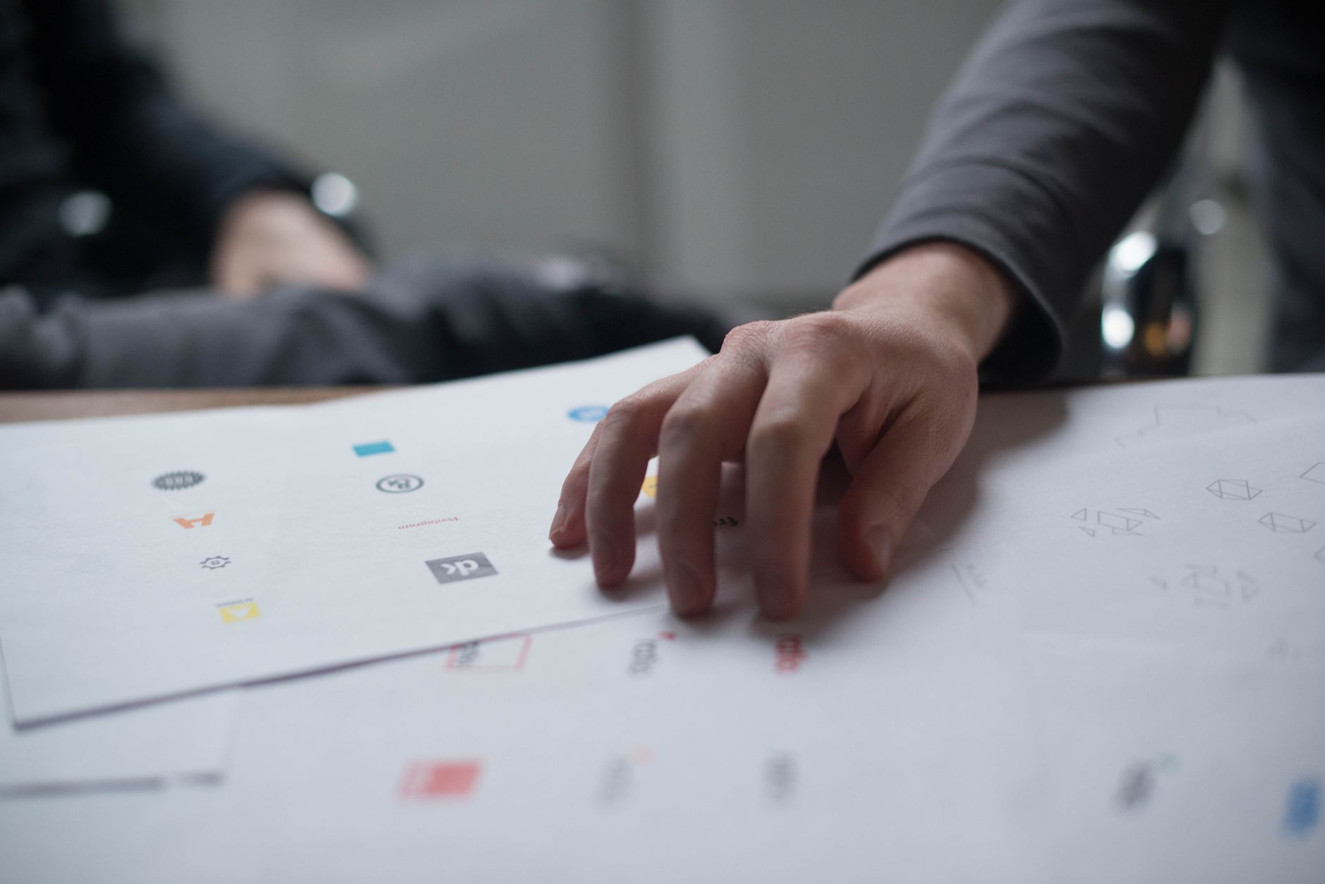 Marketing professional reviewing creative briefs and reference materials at a desk